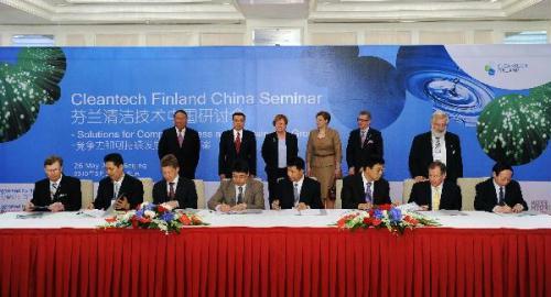 Chinese Vice Premier Li Keqiang (rear L2) and visiting Finnish President Tarja Halonen (rear L3) attend a signing ceremony after the opening ceremony of Cleantech Finland China Seminar in Beijing, capital of China, on May 26, 2010.(Xinhua/Li Tao)