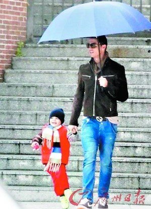 C罗大玩“慈父style” 亲自打伞接儿子放学(图)