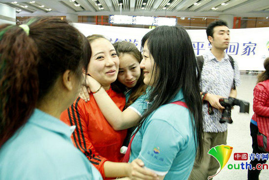 从尼泊尔回来的旅行团向导纪萌(左二),从机场出来就被同事围住。 实习记者 段然 摄