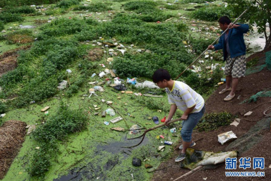 当地村民在清理沫冲引河里漂浮的垃圾（5月15日摄）。