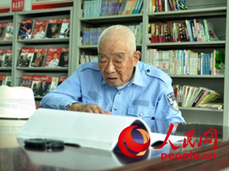 谢凤岐老人给记者念儿童团团歌（记者 曾伟 摄影）