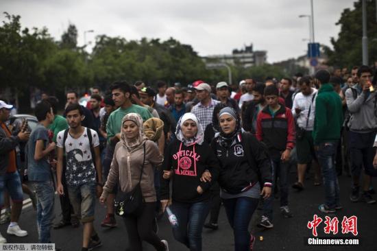 当地时间9月5日，匈牙利布达佩斯，大量难民徒步迁徙，前往奥地利与德国。由于此前布达佩斯警方封锁当地火车站，难民只能依靠双脚跨越国界。德国与奥地利近宣布对难民开放国界，数量巨大的难民从匈牙利境内徒步走向奥地利与德国。