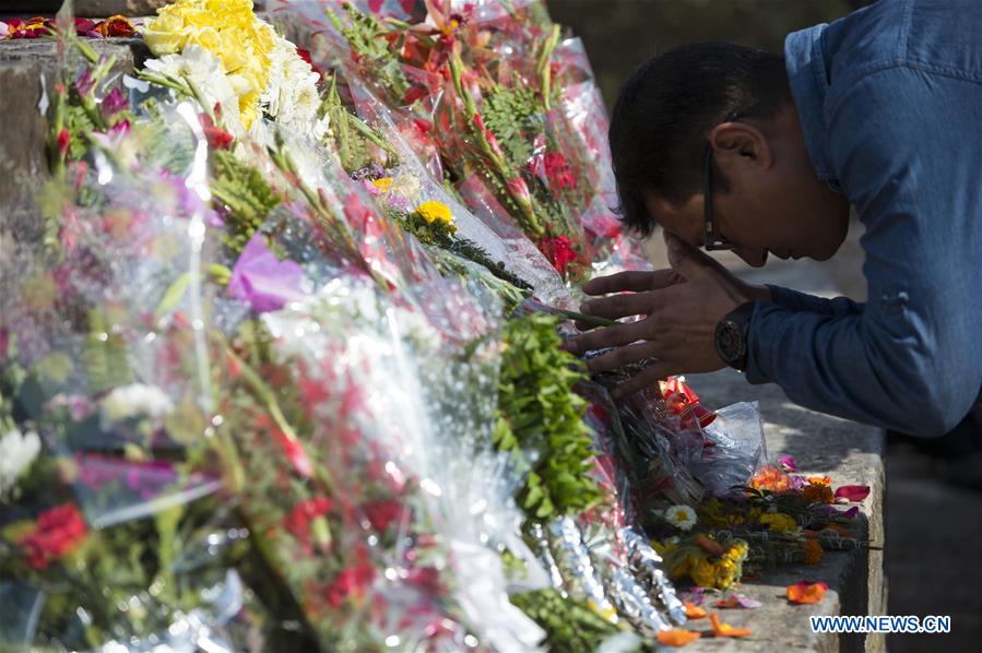  A man mourns for the earthquake victims in front of the historical nine-storey tower Dharahara premise, which completely collapsed in the quake and killed over 100 people, in Kathmandu, capital of Nepal, on April 24, 2016. Nepalese Prime Minister KP Sharma Oli offered tributes to those who lost their lives in the April 25 earthquake last year and prayed for the peace of departed souls on Sunday, marking the first anniversary of the 7.9 magnitude devastating quake. (Xinhua/Cheong Kam Ka)