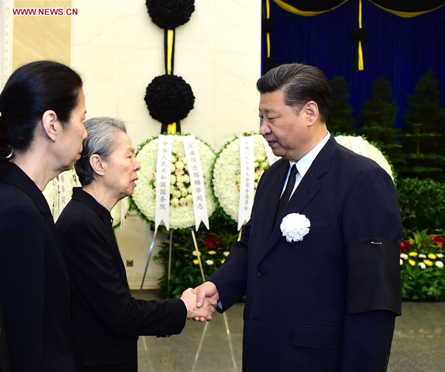 Chinese President Xi Jinping (R) shakes hands with a family member of Chen Jinhua, former vice chairman of the Chinese People