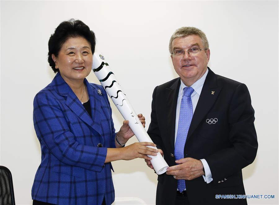 El viceprimer ministro de China, Liu Yandong recibe la antorcha olímpica desde el Presidente del Comité Olímpico Internacional, Thomas Bach, en Río de Janeiro, Brasil, 6 de agosto de 2016.(Xinhua/Han Yan)