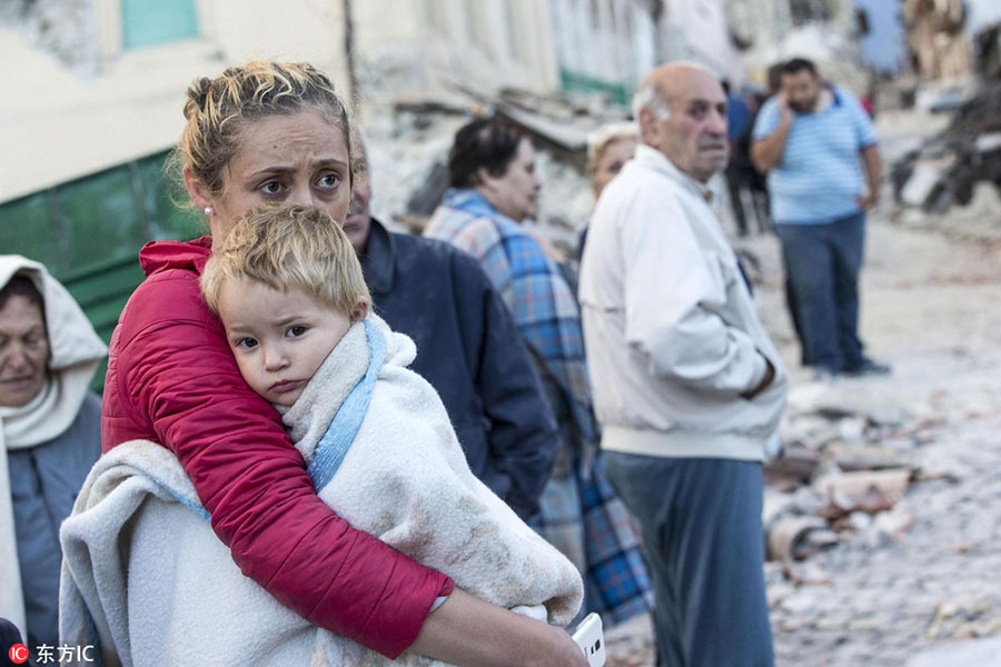 A mother embraces her son in Amatrice, central Italy, August 24, 2016. [Photo/IC]