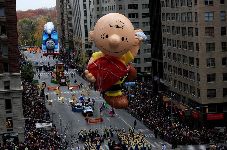 A Charlie Brown giant balloon makes its way down 6th Avenue during the 90th Macy