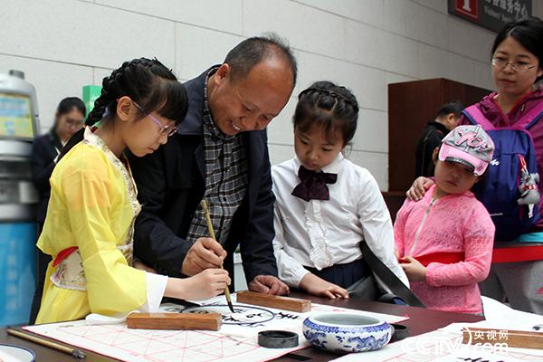 书法家指导小学员们现场书写.