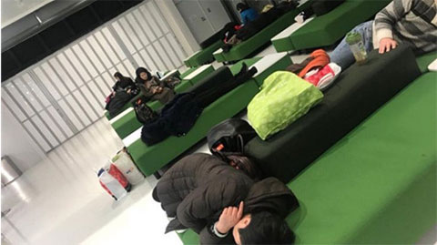 The stranded passengers rest at the airport.