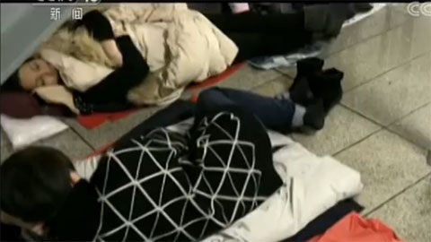 Passengers stranded at the airport sleep on the floor