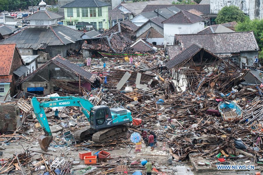 Locals have food at a damaged house in Banten Province, in Indonesia, Dec. 24, 2018. The Indonesian disaster agency on Monday put the death toll of the tsunami triggered by a volcanic eruption at 373 with 1,459 others injured, a spokesman of the agency told Xinhua on Monday. (Xinhua/Zhang Keren)