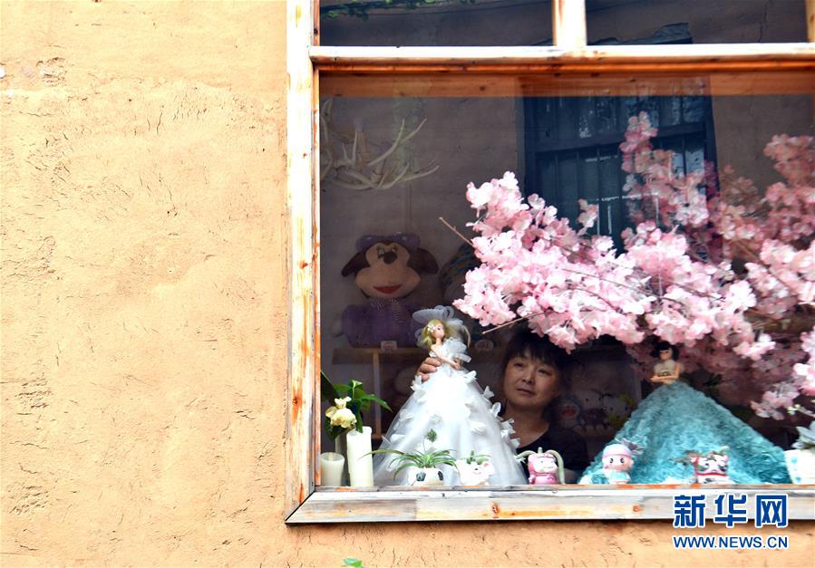 店员在田铺大塆一家文创纪念品店内整理橱窗（6月12日摄）。 新华社记者 李嘉南 摄