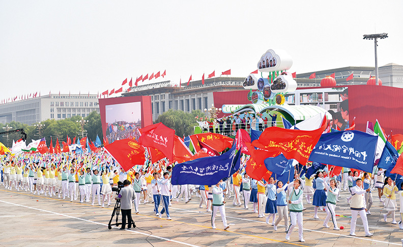 　　2019年10月1日，在庆祝新中国成立70周年大会群众游行活动中，“立德树人”方阵的教师和学生代表们挥舞着鲜花和校旗，伴着歌声走过长安街。 新华社记者 李尕/摄