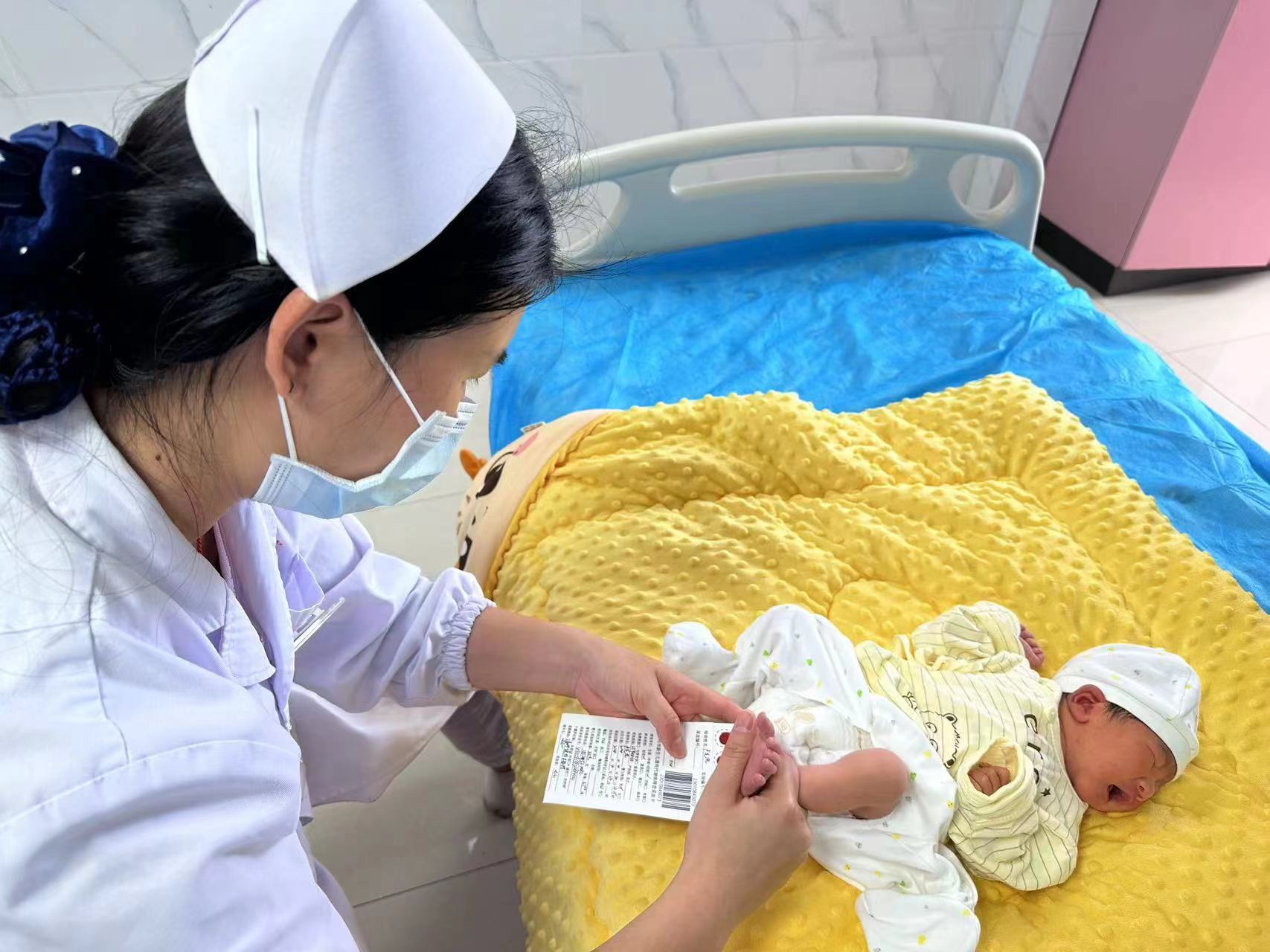 医生对新生儿进行采血筛查(马婕/摄)