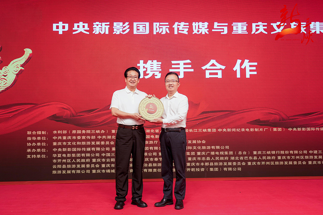 導演楊書華（左一）向重慶文旅集團贈送作品