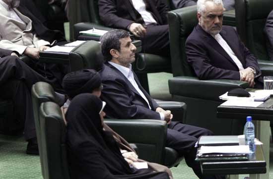 Iranian President Mahmoud Ahmadinejad, center, listens to conservative lawmaker Ali Motahari, unseen, a prominent opponent of the president, as he reads out a series of questions to Ahmadinejad in an open session in parliament in Tehran, Iran, Wednesday, March 14, 2012.