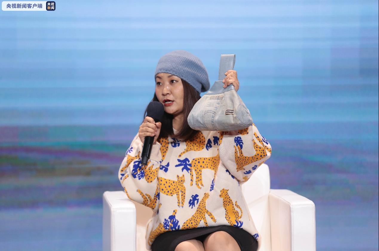 设计师张娜身着用塑料品制成的上衣,并展示用回收的牛仔裤制作而成