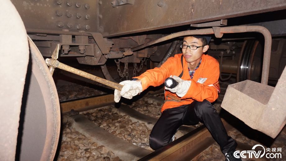 李红伟在检查车辆轮对踏面有无擦伤,剥离.