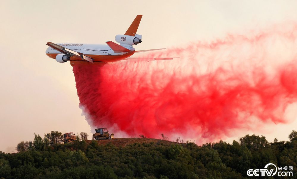 美加州山火已连烧超一周致6死 直升机撒红色阻燃剂灭火