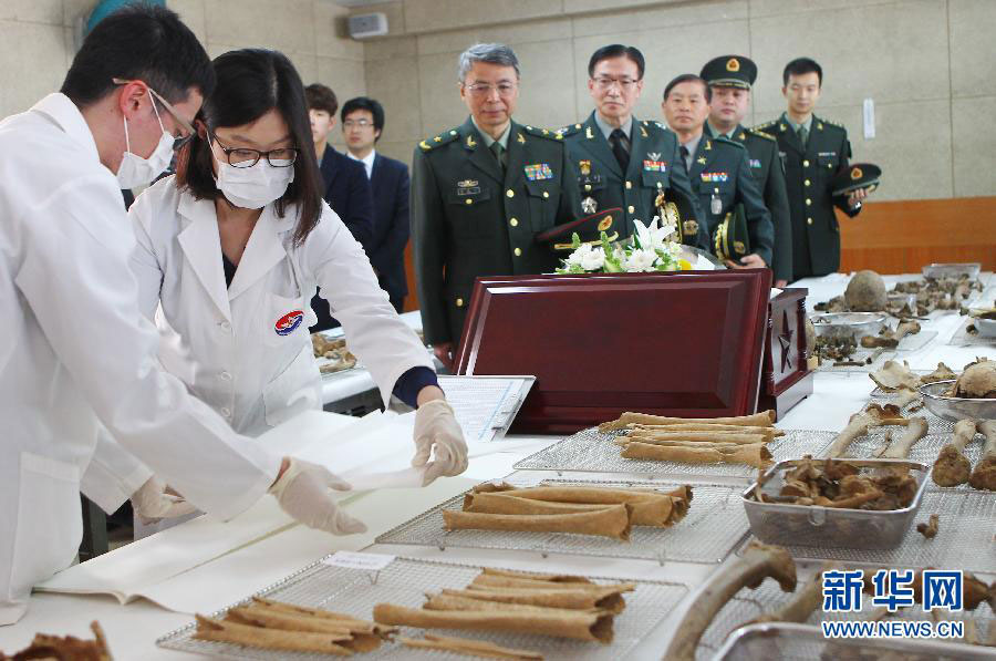 3월 16일 한국 파주에서 한국측 인원들이 중국인민지원군 열사 유해를 입관시키고 있다.