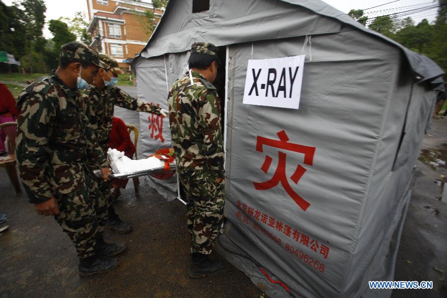 Nepalese army soldiers carry a victim for treatment at the camp of the Chinese government medical team at an army barrack in Dhulikhel, Kavre, Nepal, April 28, 2015. A 58-strong Chinese government medical team arrived in Nepal Monday morning to carry out humanitarian mission after the country was struck by a powerful earthquake at midday Saturday. (Xinhua/Pratap Thapa) 