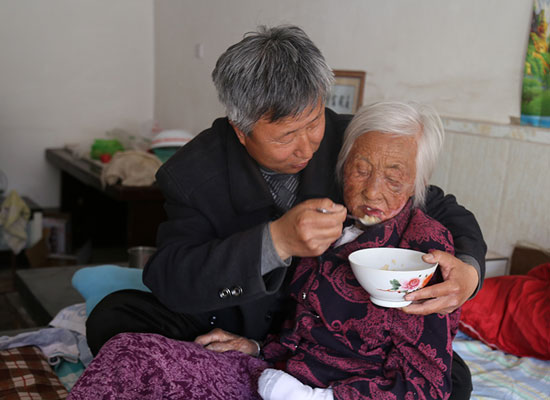 袁桂生扶着老人喂饭