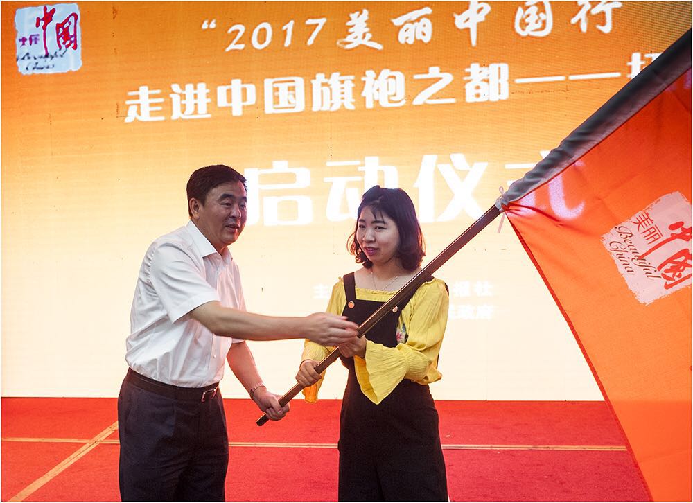 抚顺市常务副市长蒲信子向采风团代表授旗(邱磊摄)