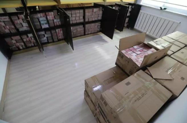 通过现场图片可以看到,被打开的壁柜里都是成捆的人民币;在房间地上落