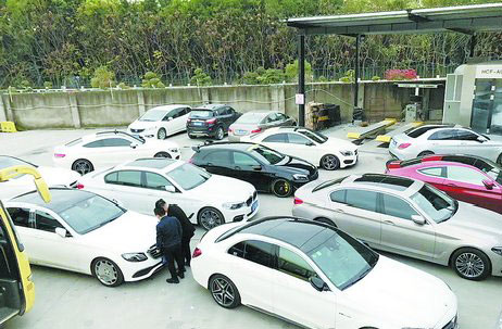 洗车店外,车辆排队等候洗车.