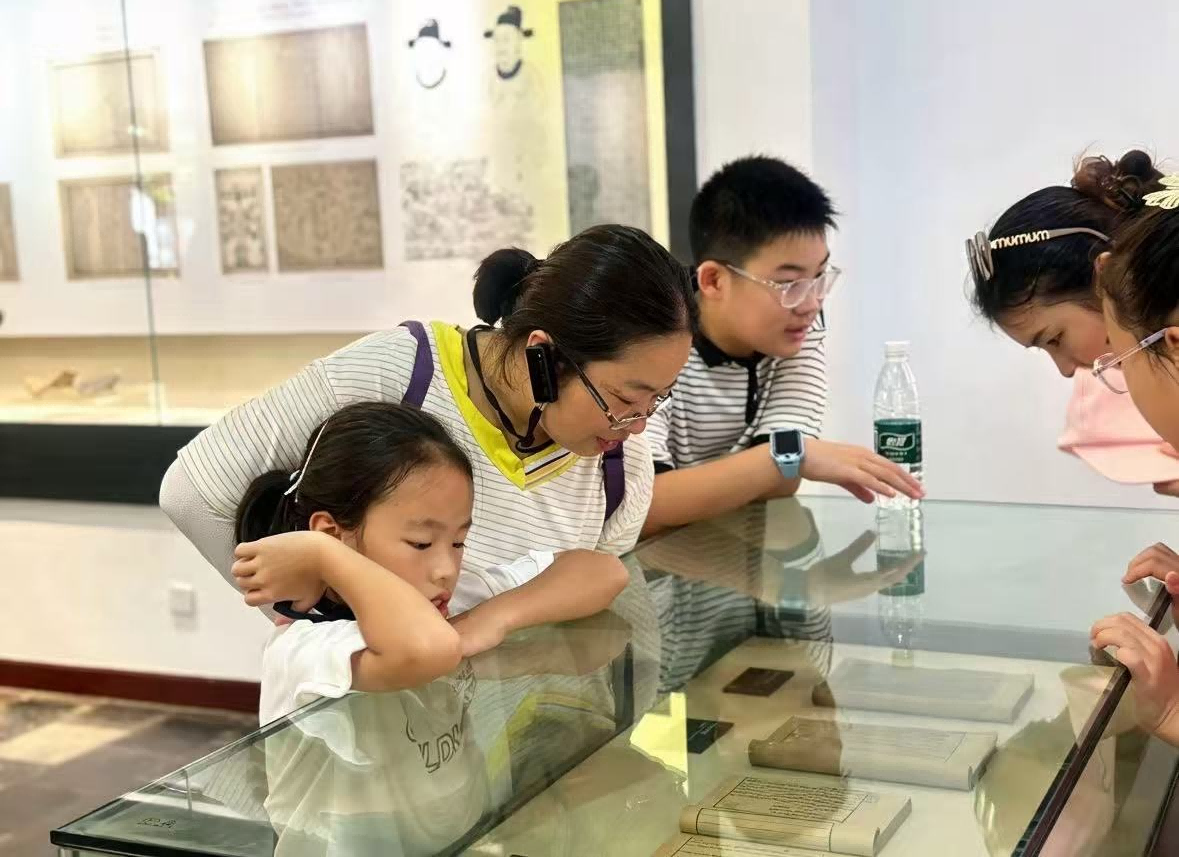岳麓书院内，家长带着孩子品读古籍